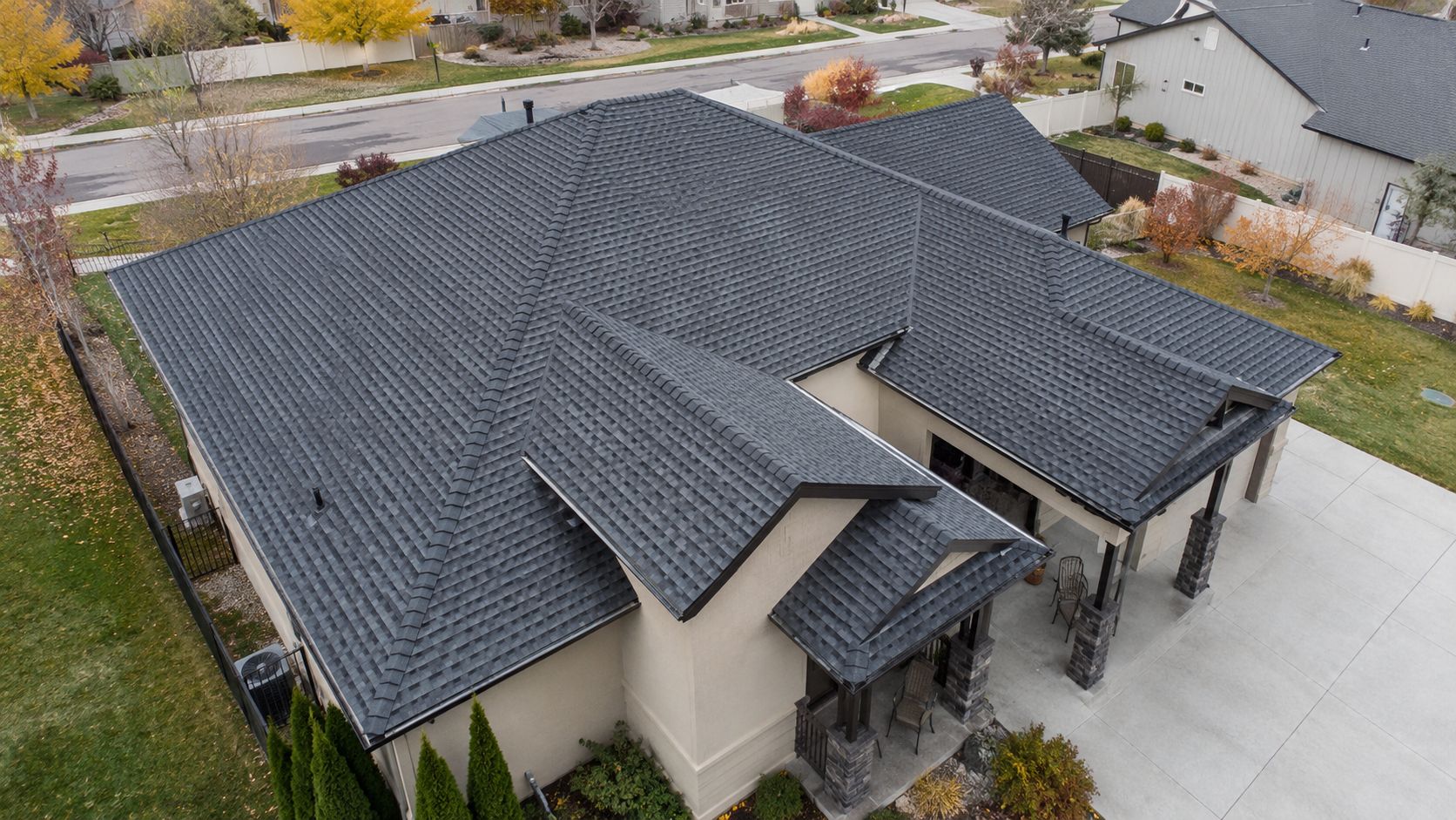 aerial view of a residential roof with dark gray shingles